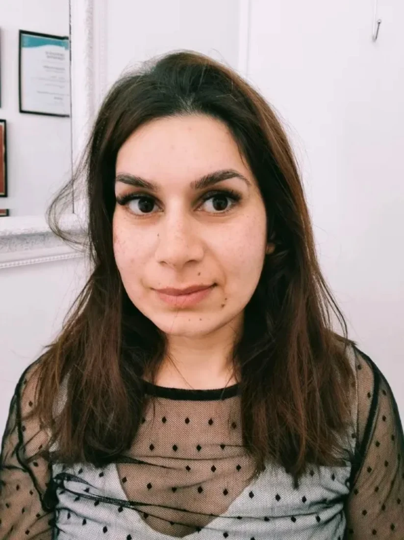 A client in a sheer polka-dot top, her lash extensions curled and her brows tinted